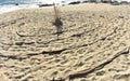 Circular labyrinth on Pacific beach seashore background