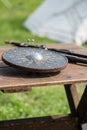 Circular and Metallic Shield on Wooden table: Medieval Metallic Armors and Weapons