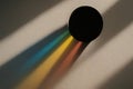 Sunlight creates vibrant rainbow shadows from a circular object on a textured wall Royalty Free Stock Photo