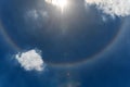 Circular rainbow surround the sun on blue sky with clouds. Sun haloÃ¢â¬â¹ phenomenon Royalty Free Stock Photo