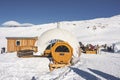 Circular sauna and curved ski resort against snowy mountain