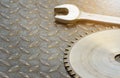 Circular saw blade focus on saw tooth And a wrench placed on the steel floor with copy space- top view