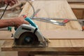 Circular saw cutting piece of wood in carpentry workshop