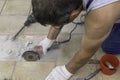 A circular saw. A man sawing ceramic tiles. Worker sawing a tile on a circular saw. Construction works. Selective focus