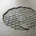 A circular section of hexagonal wire mesh is exposed on a text Royalty Free Stock Photo