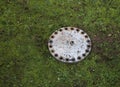 Cast iron lid on the lawn hides a secret trap of a passage to hi Royalty Free Stock Photo