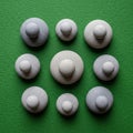 Circular, stone-like objects arranged in a grid on a textured green Royalty Free Stock Photo