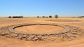 A circular stone structure in the middle of a desert. Generative AI image.