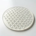 Circular white silicone pad with a grid of raised dots on one side Royalty Free Stock Photo
