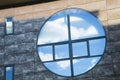 Circular window reflecting a blue sky