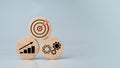 Circular wood with printed target icons and business symbols on white background, business goals and objectives concept, business