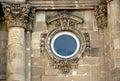 Circular wooden window in renaissance stone facade