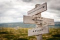 circumstances alter faces text engraved on old wooden signpost outdoors in nature