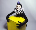 Circus fashion mime posing near a yellow square