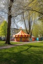 circus tent in a park with childrens playground nearby