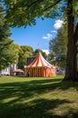 circus tent in a park with childrens playground nearby