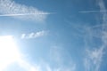 Cirrus clouds and long airplane trail row. Aero plane contrail in blue cloudy sky background. Horizontal line track from flying