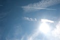 Cirrus clouds and long airplane trail row. Aero plane contrail in blue cloudy sky background. Horizontal line track from flying