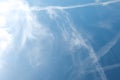 Cirrus clouds and long airplane trail row. Aero plane contrail in blue cloudy sky background. Horizontal line track from flying