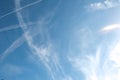 Cirrus clouds and long airplane trail row. Aero plane contrail in blue cloudy sky background. Horizontal line track from flying