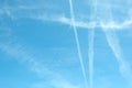 Cirrus clouds and long airplane trail row. Aero plane contrail in blue cloudy sky background. Horizontal line track from flying Royalty Free Stock Photo