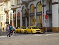 Citizens walk among parked taxis in the center of Prague.