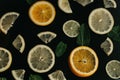 Citrus on a black background. Many slices of lemon, orange, lime and mint leaves lie together. A lot of fruits. Vitamins Royalty Free Stock Photo