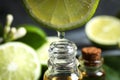 Citrus essential oil dripping from lime slice into bottle