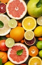 Citrus fruit food background, top view. Mix of different whole and sliced fruits: orange, grapefruit, lime and other with leaves