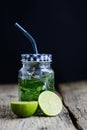 Citrus fruit and herbs infused sassi water for detox or dieting in glass bottles on wooden board, dark background Royalty Free Stock Photo