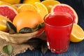 Citrus fruit. Various citrus fruits with leaves of lemon, orange, grapefruit in a basket and grapefruit juice on a blue wooden tab Royalty Free Stock Photo