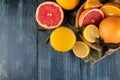 Citrus fruit. various citrus fruits with leaves of lemon, orange, grapefruit in a basket and orange juice on a blue wooden table. Royalty Free Stock Photo