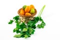 Citrus fruits in a basket exotic kumquats and limequats on a white isolated background and with greens