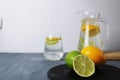 citrus fruits lemon and lime lie on a black tray and lemonade in a cubit glass. Preparation of drinks. Soft drinks Royalty Free Stock Photo