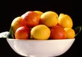 Citrus fruits in plate on black background