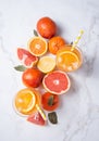 Citrus juice in two glasses and fresh fruit tangerine orange grapefruit and lemon on a marble background Royalty Free Stock Photo