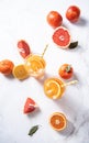 Citrus juice in two glasses and fresh fruit tangerine, orange, grapefruit and lemon on a  marble background Royalty Free Stock Photo