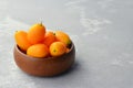 Citrus kumquat fruits in wooden bowl. Healthy vegan food. Side view, copy space. Royalty Free Stock Photo