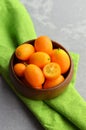 Citrus kumquat fruits in wooden bowl on linen cloth. Healthy vegan food. Royalty Free Stock Photo