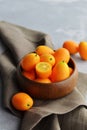 Citrus kumquat fruits in wooden bowl on linen cloth. Healthy vegan food Royalty Free Stock Photo