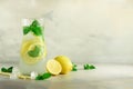 Citrus lemonade - cold water with ice, mint, lemon on grey background. Detox drink. Summer fruit infused water. Copy Royalty Free Stock Photo