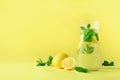 Citrus lemonade - cold water with ice, mint, lemon on yellow background. Detox drink. Summer fruit infused water. Copy Royalty Free Stock Photo