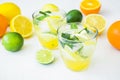 Citrus lemonade with limes and lemons in glasses on white table Royalty Free Stock Photo