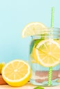 Citrus lemonade water with sliced lemon and mint, healthy and detox water drink in summer on wooden table with blue lighten Royalty Free Stock Photo