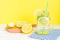 Citrus lemonade water with sliced lemon and mint, healthy and detox water drink in summer on wooden table with yellow background Royalty Free Stock Photo