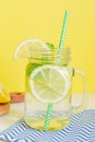 Citrus lemonade water with sliced lemon and mint, healthy and detox water drink in summer on wooden table with yellow background Royalty Free Stock Photo