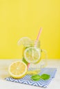 Citrus lemonade water with sliced lemon and mint, healthy and detox water drink in summer on yellow background. Summer bright Royalty Free Stock Photo