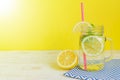 Citrus lemonade water with sliced lemon and mint leaves, healthy and detox water drink in summer on wooden table with bright Royalty Free Stock Photo