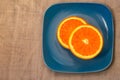 Citrus. A mandarin is served on a blue plate.