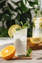 Citrus mint lemonade with ice cubes in glass Cup next to vintage carafe. Summer drink Limoncello Royalty Free Stock Photo